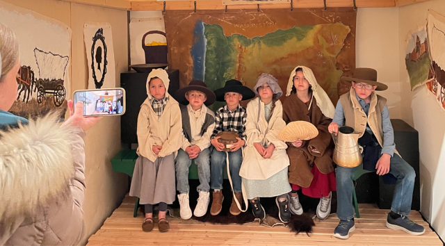 group of children in old time costume posing for a photo