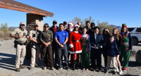 17 BLM volunteers pose for photo at toy giveaway.